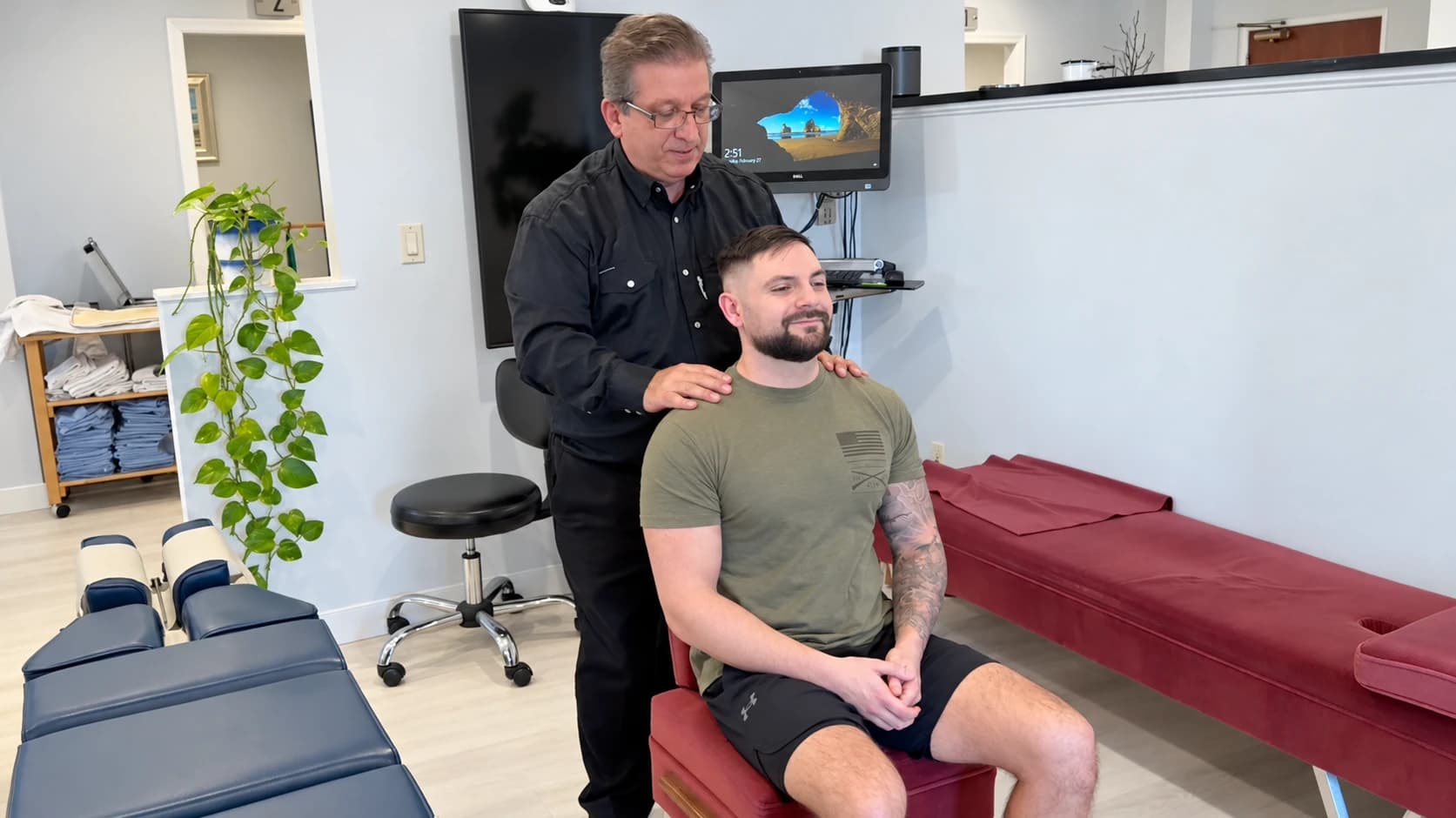 Dr. Henry Madalian with his hands resting on a seated patient's shoulders at our Wayne office